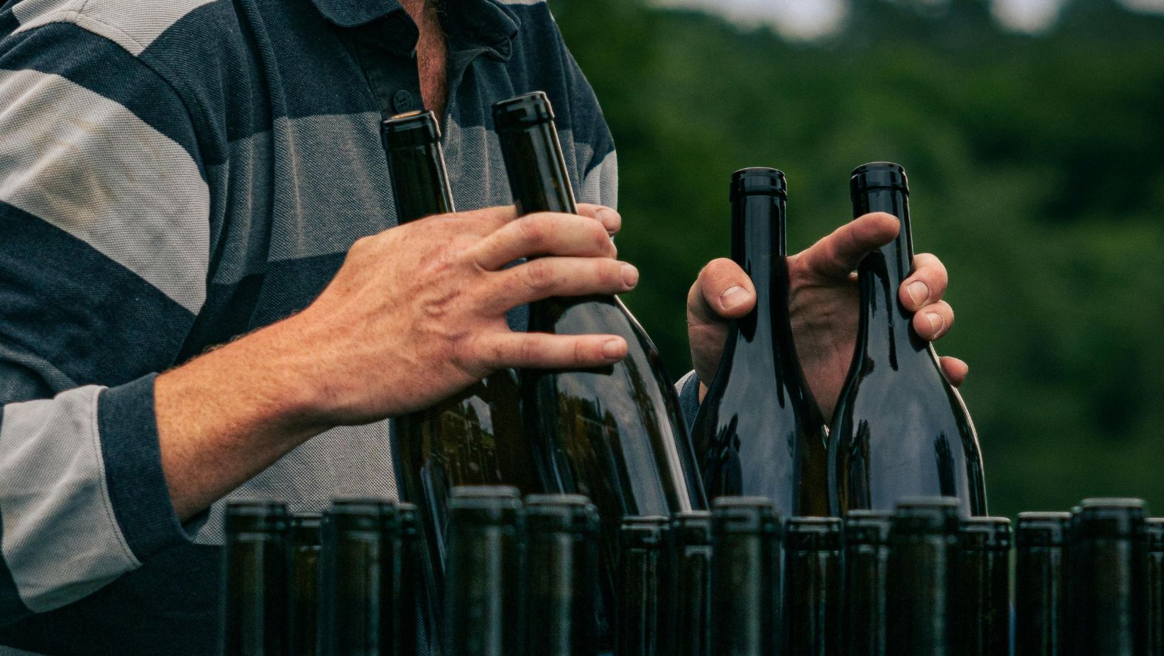 Why do wine bottles have longer necks than other beverages?