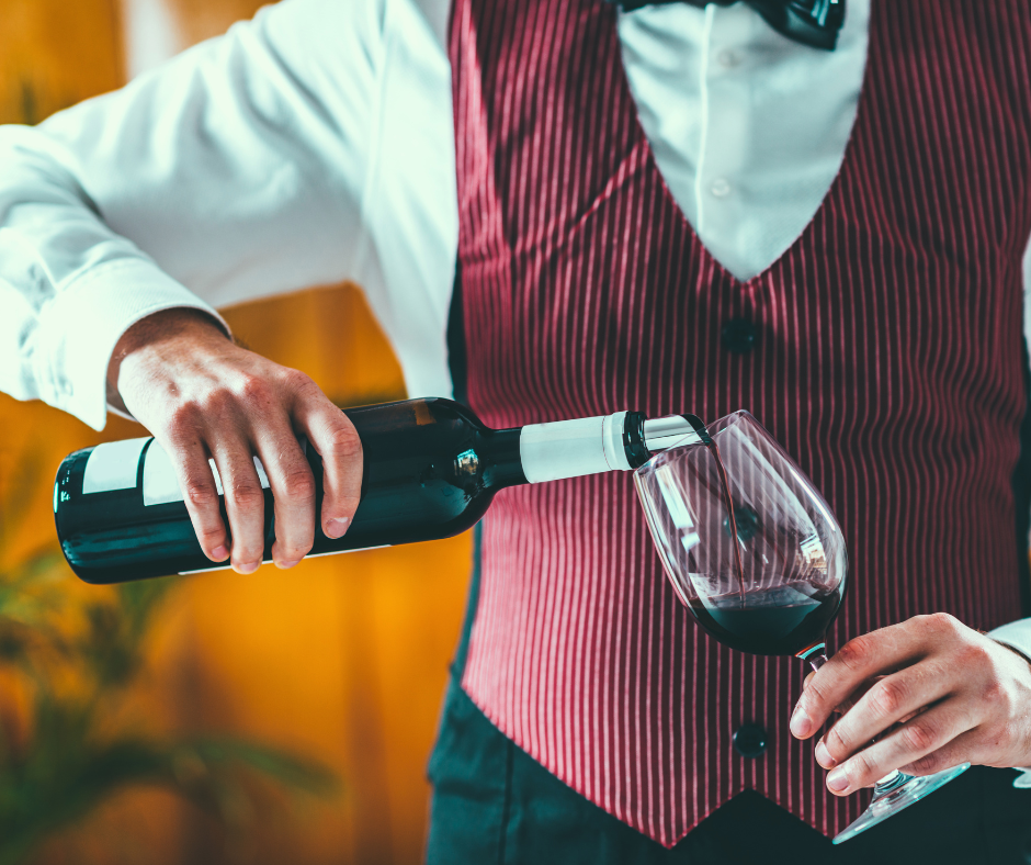 Should I hold my glass up while serving wine?